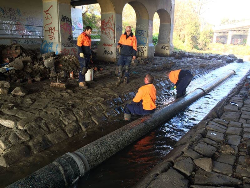 Workers install large pipe.
